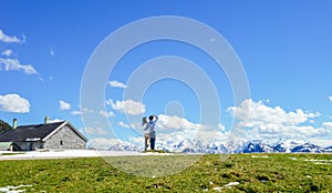 Young couple stand on edge of Schafberg mountain, Austria