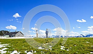 Young couple stand on edge of Schafberg mountain, Austria