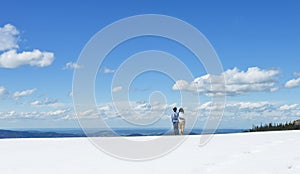 Young couple stand together looking far on Schafberg mountain, Austria