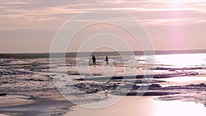 Young couple standing on the bank of the winter sea.