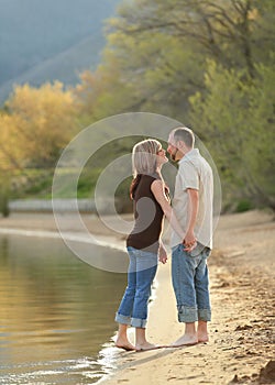 Young couple standing on beach together full-length