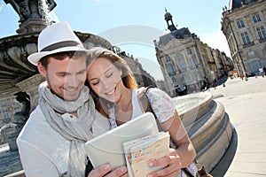 Young couple standing in city center looking at mep