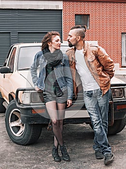 Young couple standing near the car in the city Parking lot