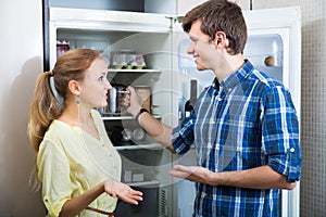 Young couple standing near refrigerator photo