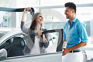 Young Couple Standing Near then New Car and Holding a Key