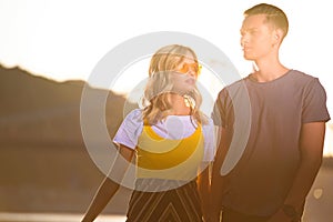 young couple standing on river beach