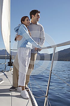 Young couple standing on sailboat
