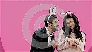 Young couple standing standing on pink background. During this time, they are dressed in rabble ears. Looking at each