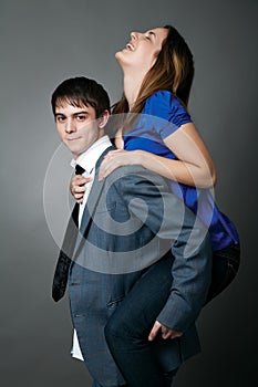 Young couple standing together against a grey wall