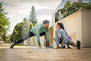 Young couple stretching on the sidewalk after running. photo