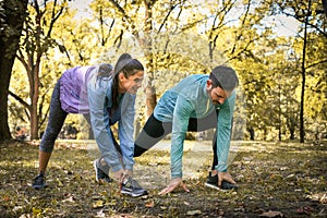 Young couple stretching before running in city park. On the move