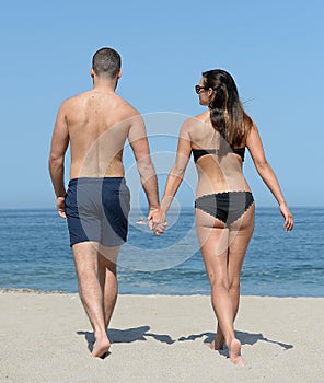 Young couple strolling on sandy beach