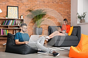 Young couple studying with laptops at home