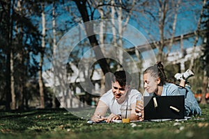 Young couple studying together outdoors on a sunny day