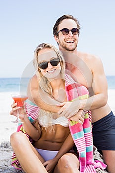 Young couple in sunglasses embracing on the beach