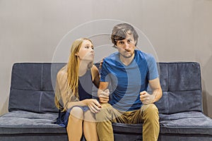 Young couple swears on the couch. Watch and evaluate their behavior from the side. Emotional intelligence concept