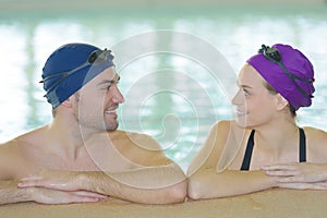 Young couple swimmers inside swimming pool