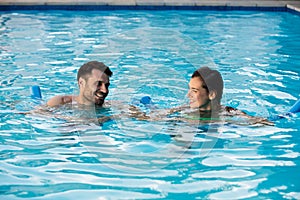 Young couple swimming with inflatable tubes