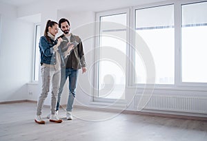 Young couple with tablet moving and planning in new flat, new home and relocation concept.