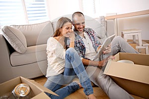 Young couple with tablet at their new flat