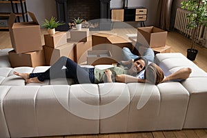 Young couple take break in renovating home rest on couch