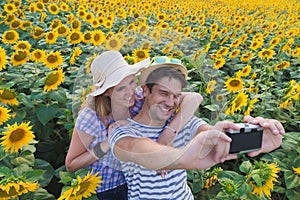 Young couple taking photos in sunflower field