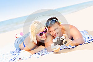 Young couple taking pictures at the beach