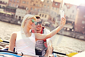 Young couple taking pictures in a canoe