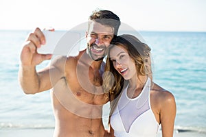 Young couple taking selfie at beach