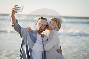 Young couple taking selfie at beach