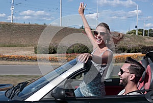 Young couple taking selfie in convertible car?