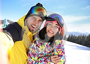 Young couple taking selfie at ski resort. Winter vacation