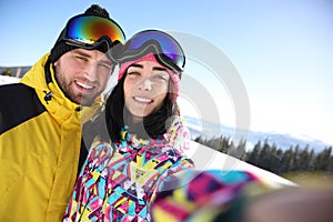 Young couple taking selfie at ski resort