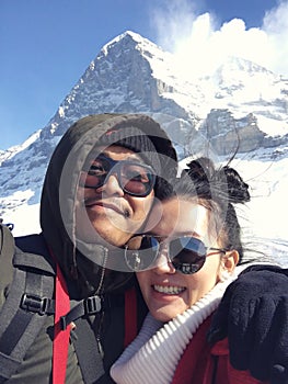 Young couple taking a selfie on snow mountain in Switzerland