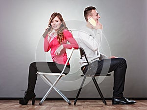 Young couple talking on mobile phones.