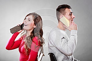 Young couple talking on mobile phones.