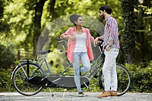 Young couple by the the tandem bicycle