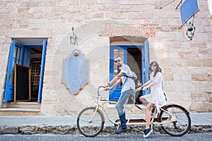 Young couple on tandem bicycle at the street city