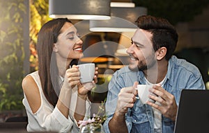 Young couple tasting coffee enjoying flirt and conversation in cafe