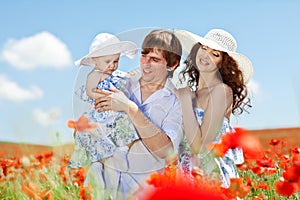 Young couple and their baby-girl in poppy field