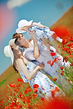 Young couple and their baby-girl in poppy field