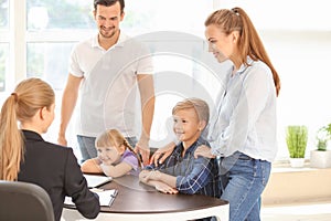 Young couple and their children meeting with headmistress at school