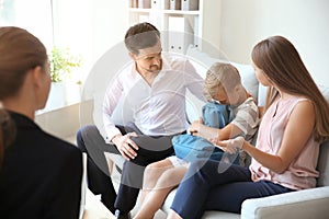 Young couple and their son meeting with headmistress at school