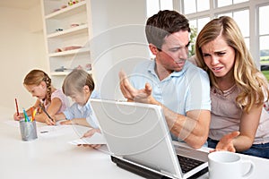 Young couple thinking and looking at a laptop