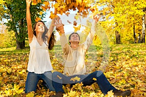 Young couple throwing autumn leaves