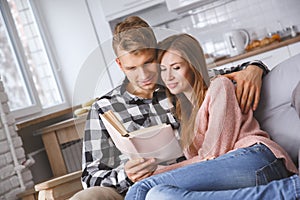 Young couple together at home love concept reading book