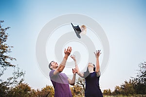 Young couple tossing hats into the air