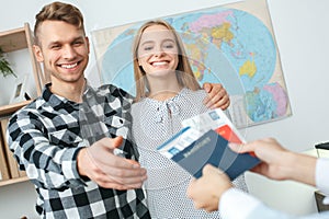 Young couple in a tour agency communication with a travel agent travelling concept taking documents