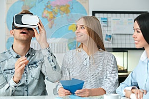 Young couple in a tour agency communication with a travel agent travelling concept virtual reality headset excited