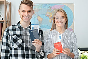 Young couple in a tour agency travelling concept holding documents